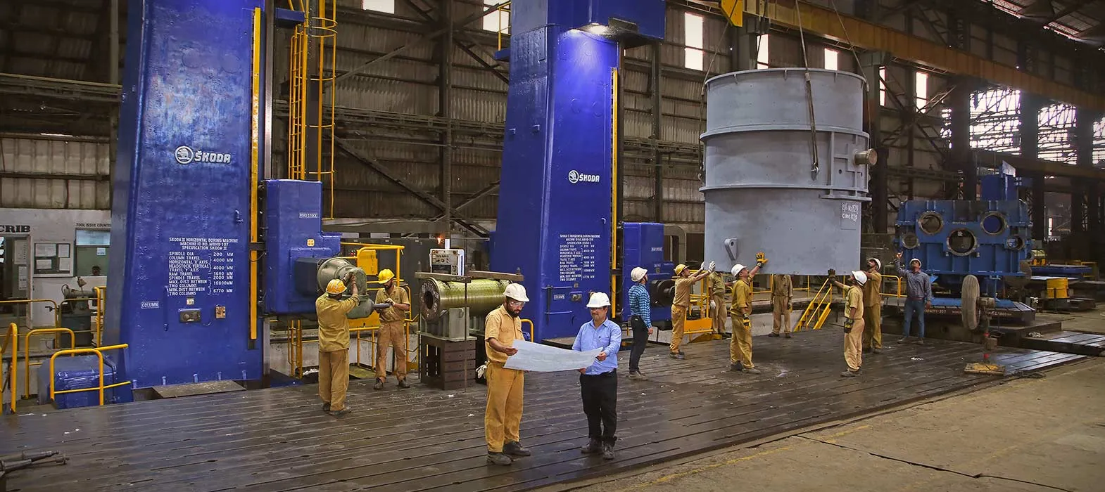Workers operating custom-built industrial machinery.