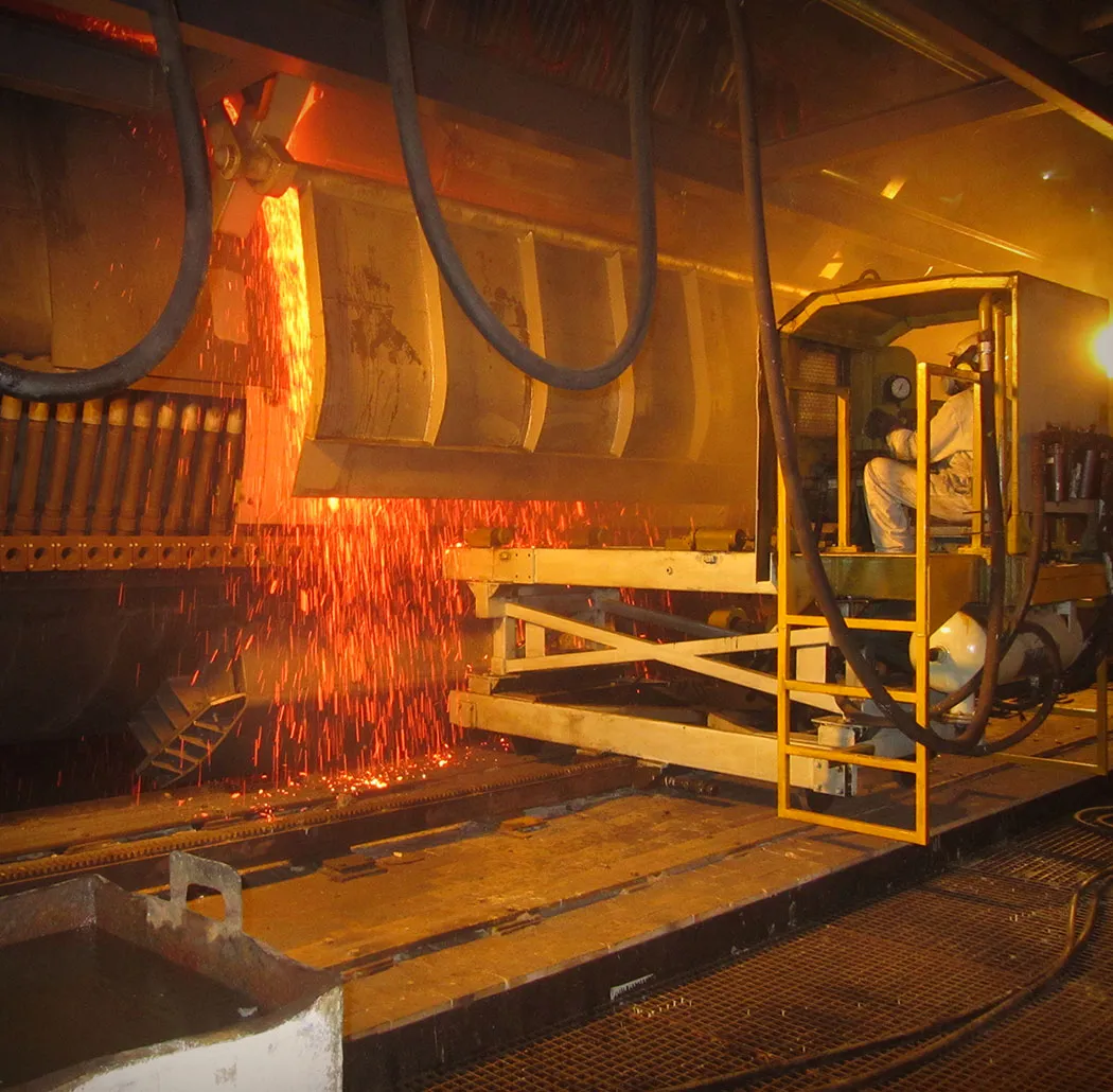 Glowing molten metal flowing through industrial machinery.
